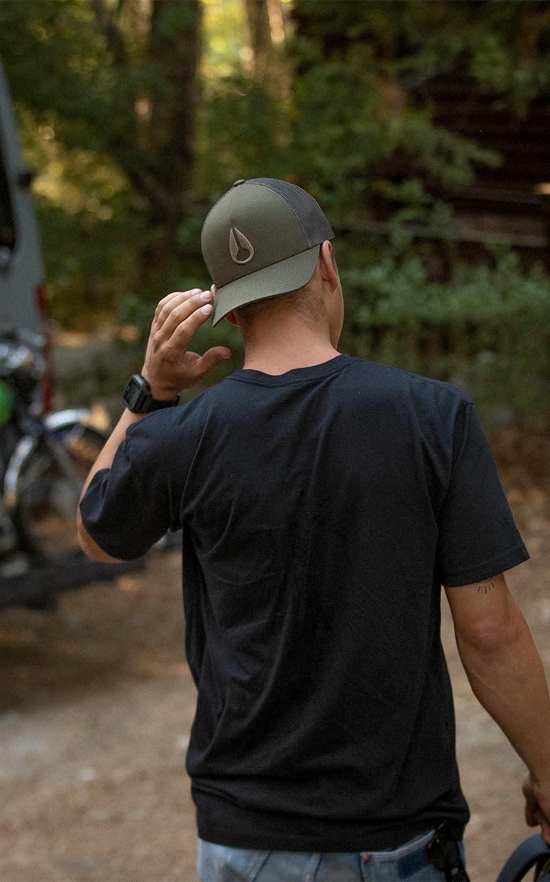 Man in the forest wearing a Nixon hat